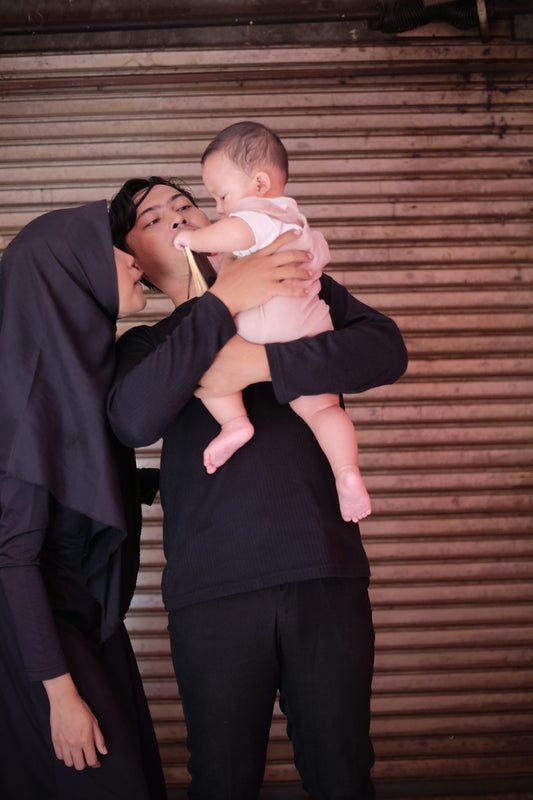 a couple of people that are holding a baby