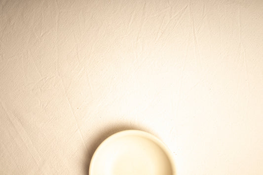 A white plate sitting on top of a white wall