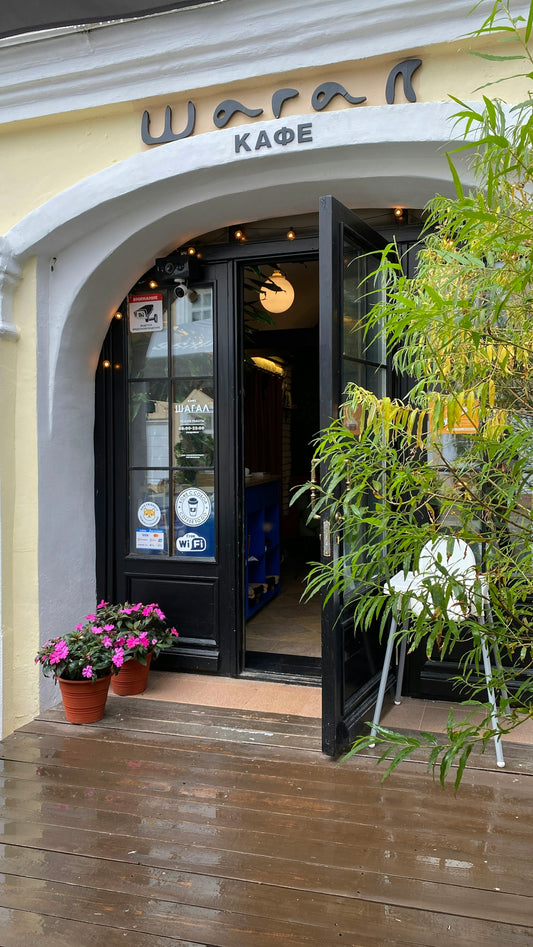 A store front with potted plants outside of it